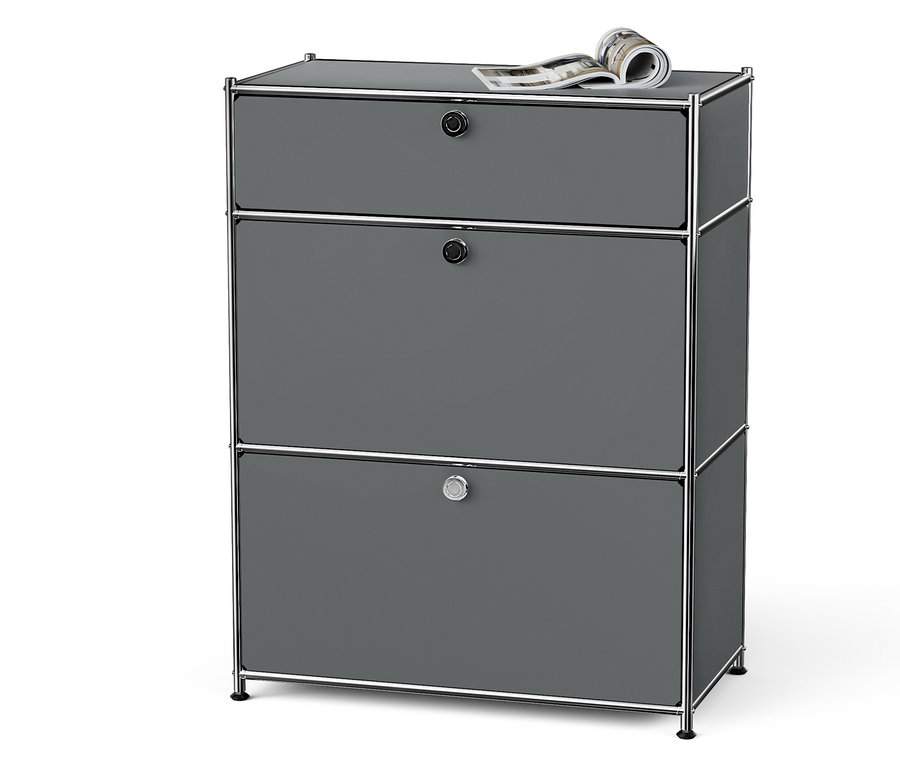 Šedá komoda se třemi zásuvkami a chromovaným rámem a časopisem nahoře.