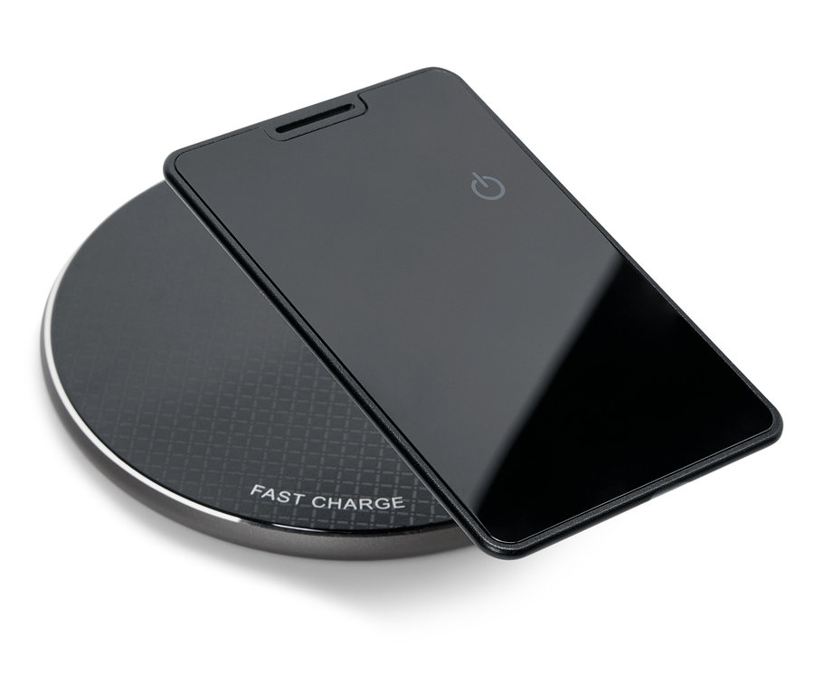 Černý telefon leží na černé bezdrátové nabíječce.