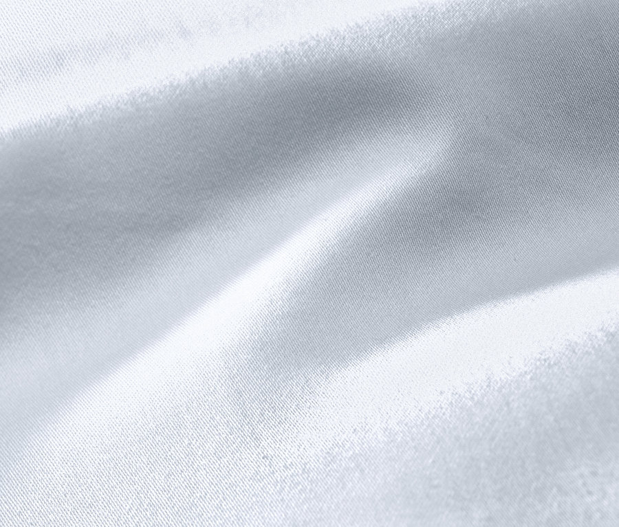 Detailní záběr bílého bavlněného saténového povlečení nadměrné velikosti.