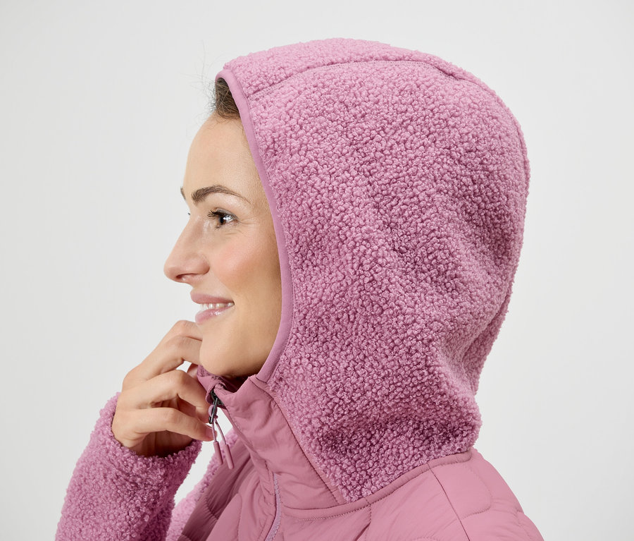Žena v růžové bundě s kapucí.