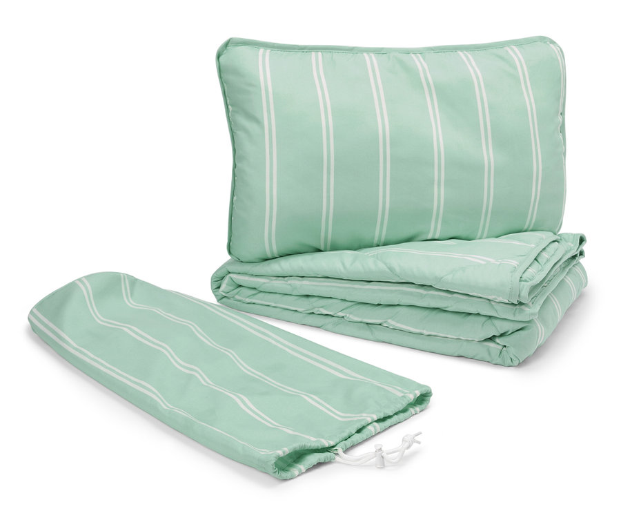 Zelený prošívaný polštář a deka s bílými pruhy vedle obalu se stahovací šňůrkou.
