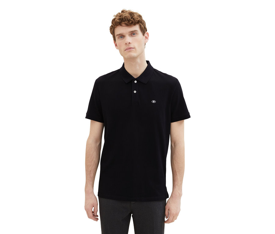 Muž má na sobě černé piké polokošile Tom Tailor.