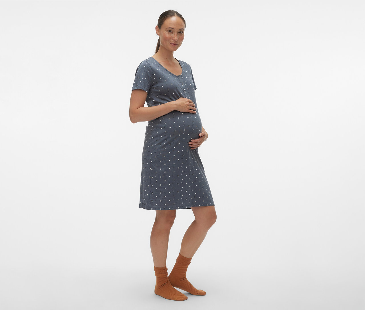 Těhotná žena drží si břicho a má na sobě modrou noční košili MAMALICIOUS »MLMIRA« s bílými puntíky.