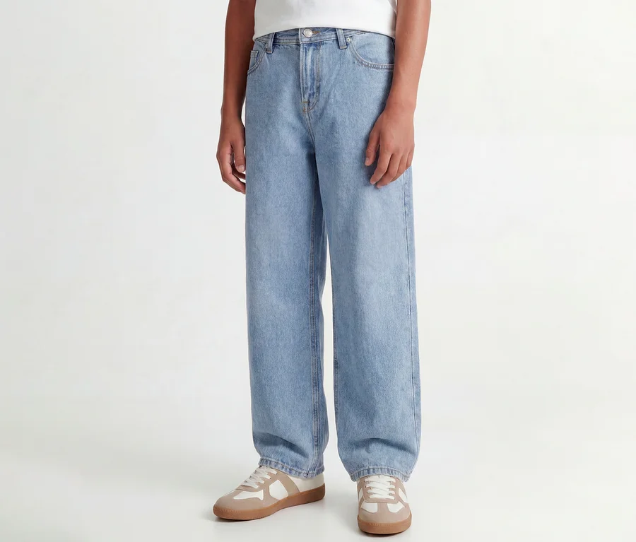 Osoba má na sobě světle modré džíny Jack & Jones JJOriginal Alex a béžovo-bílé tenisky.