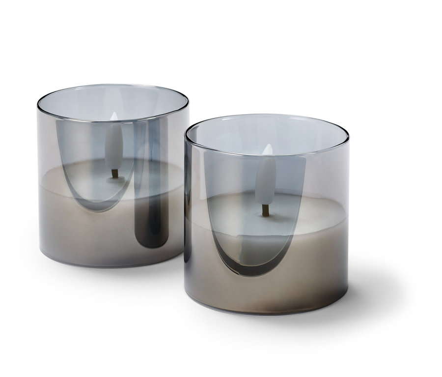 Dvě malé LED svíčky z pravého vosku ve skleněném obalu.