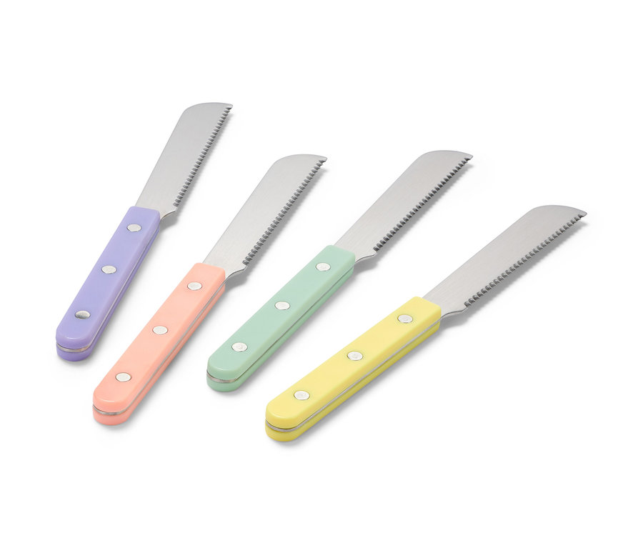 Čtyři snídaňové nože s barevnými rukojeťmi, fialovou, broskvovou, zelenou a žlutou, leží na bílém povrchu.