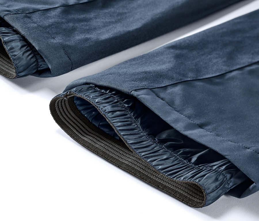 Detail modrých lyžařských kalhot s vysokým pasem.