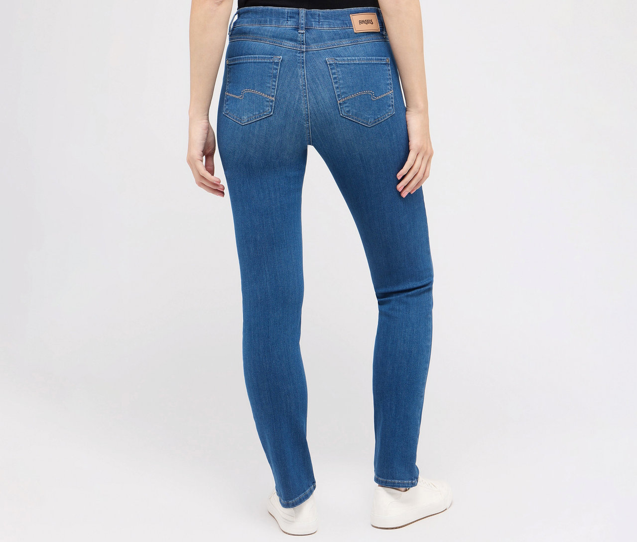 Pohled zezadu na ženu nosící džíny Angels »Cici« slim fit, mid blue a bílé boty.