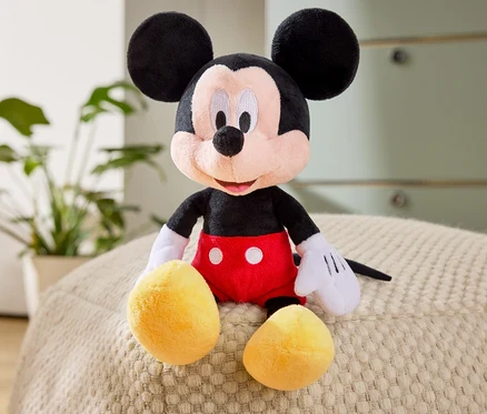 Plyšová hračka Mickey Mouse sedí na pufu.