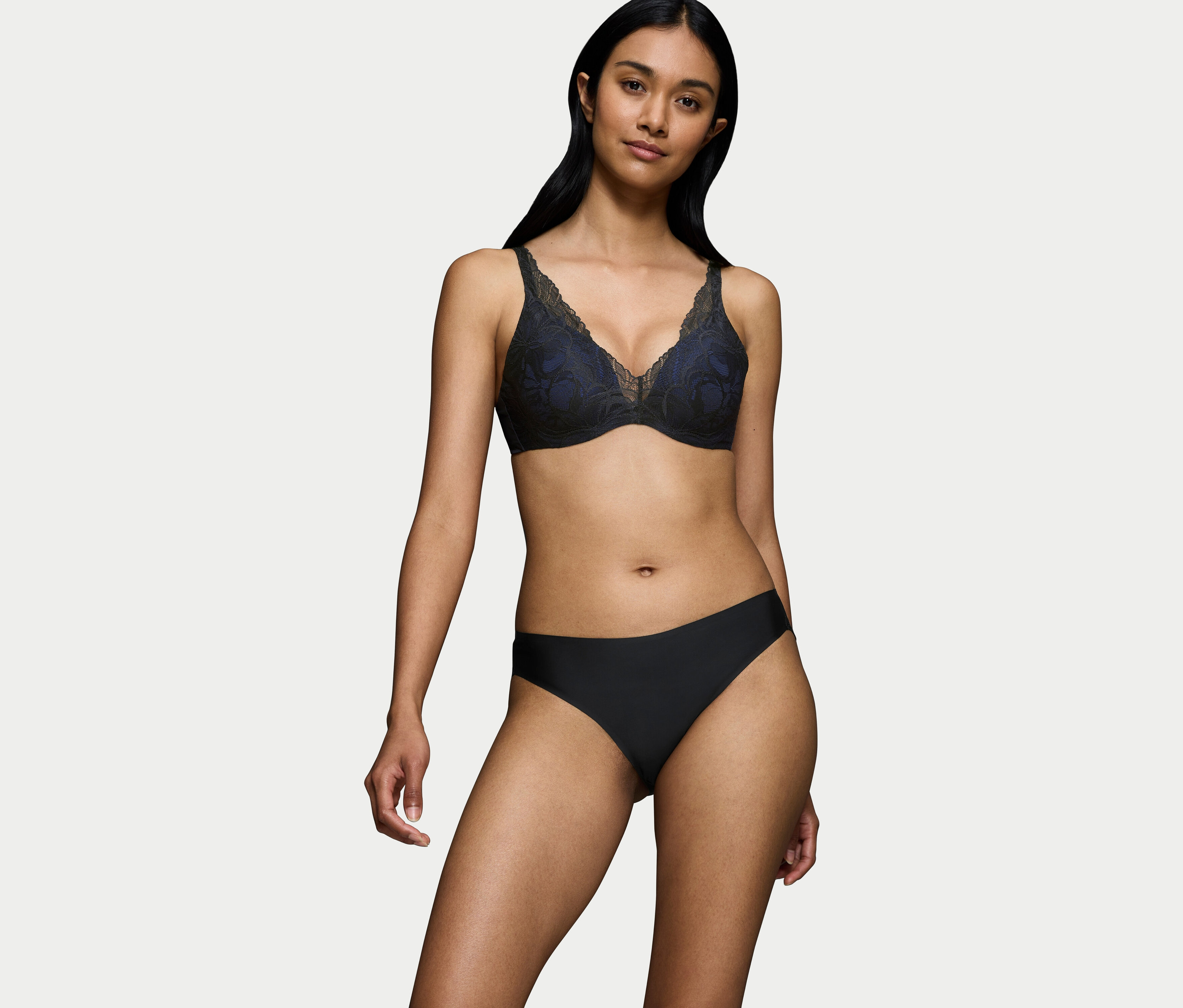 Žena má na sobě černou krajkovou podprsenku a černé kalhotky.