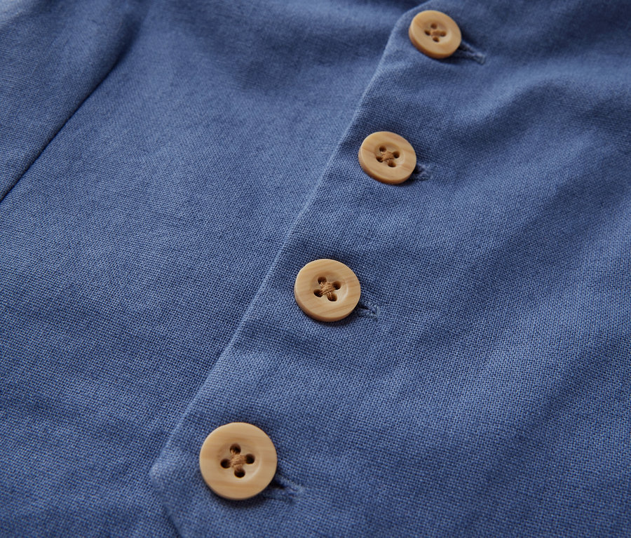 Detail dětské vesty s knoflíky.