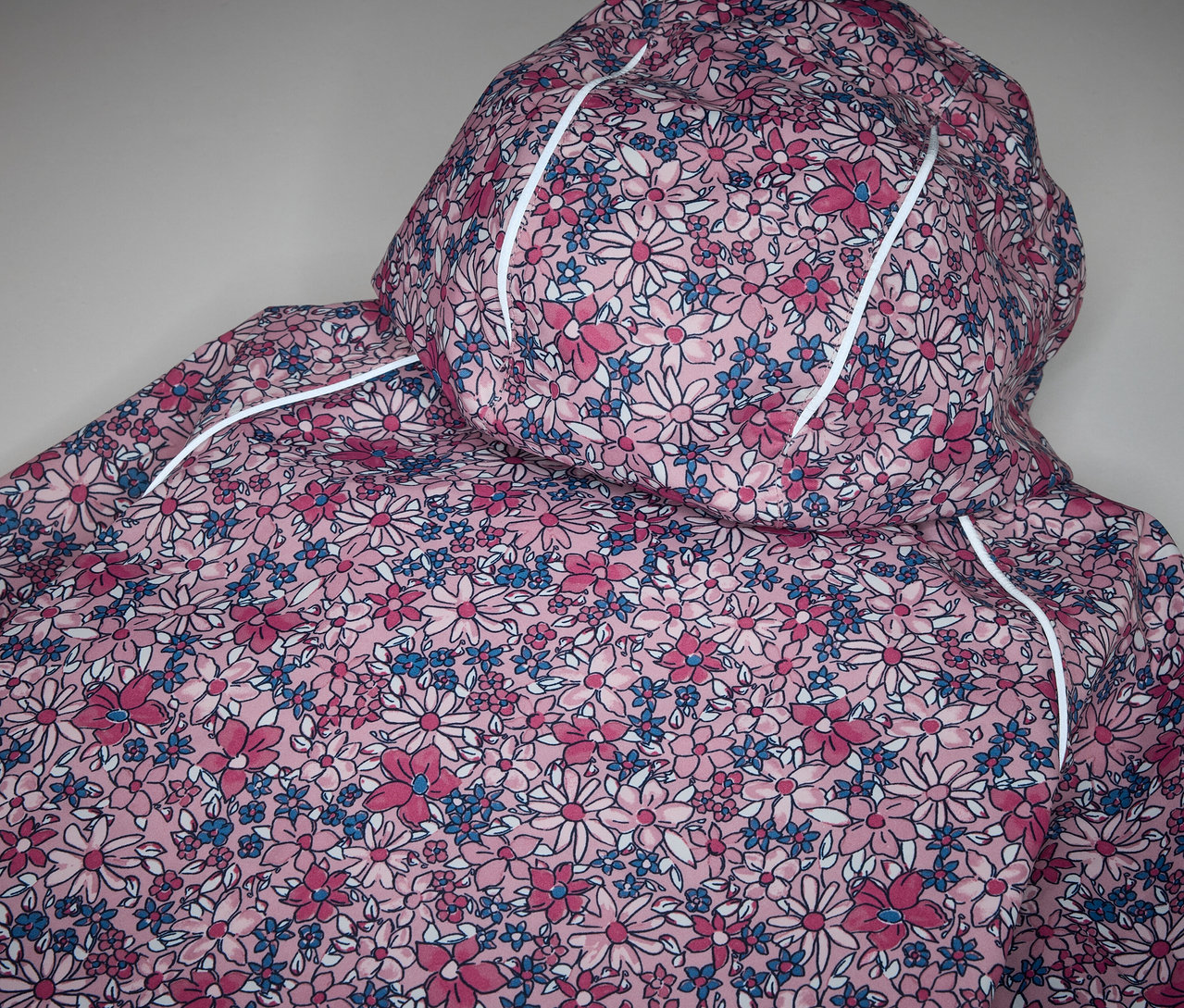 Detail dětské termo bundy do deště s květinovým vzorem.