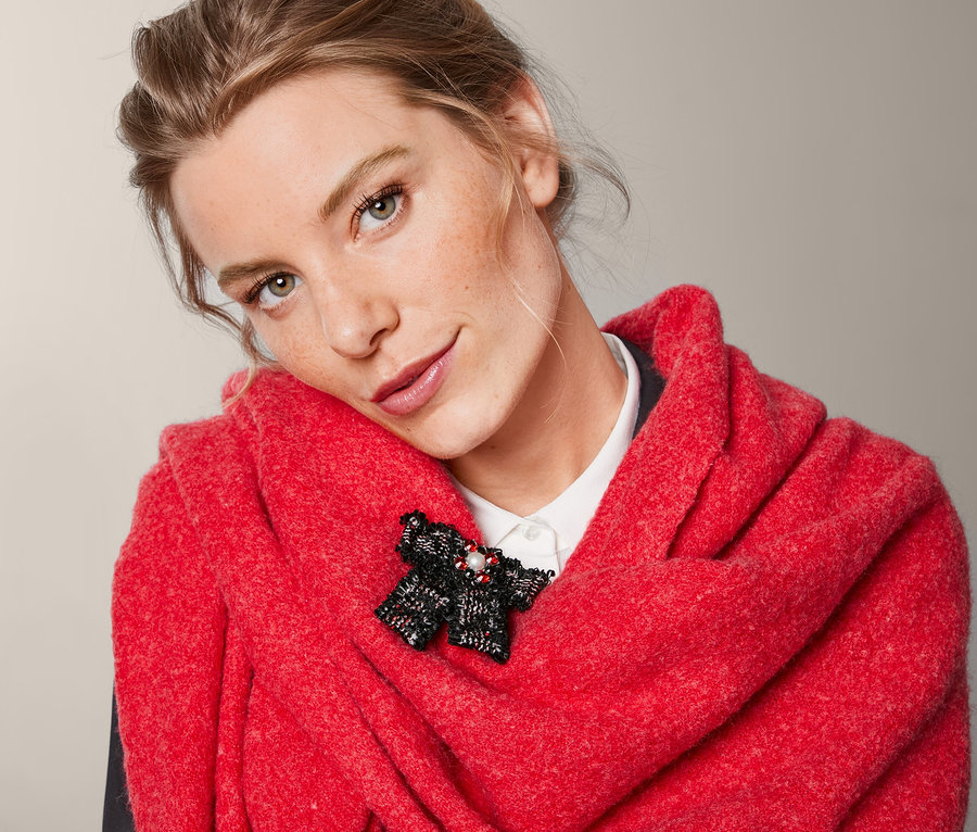 Žena s červeným šálem a tvídovou mašlí s broží.