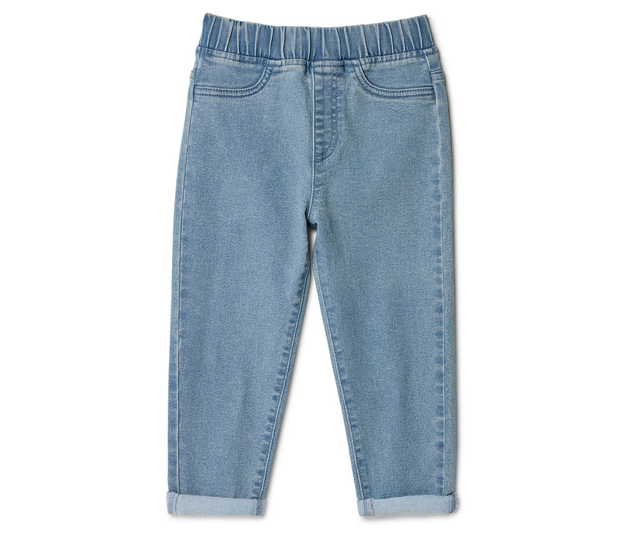 Světlé džíny s elastickým pasem a ohrnutými nohavicemi ležící na bílém pozadí.