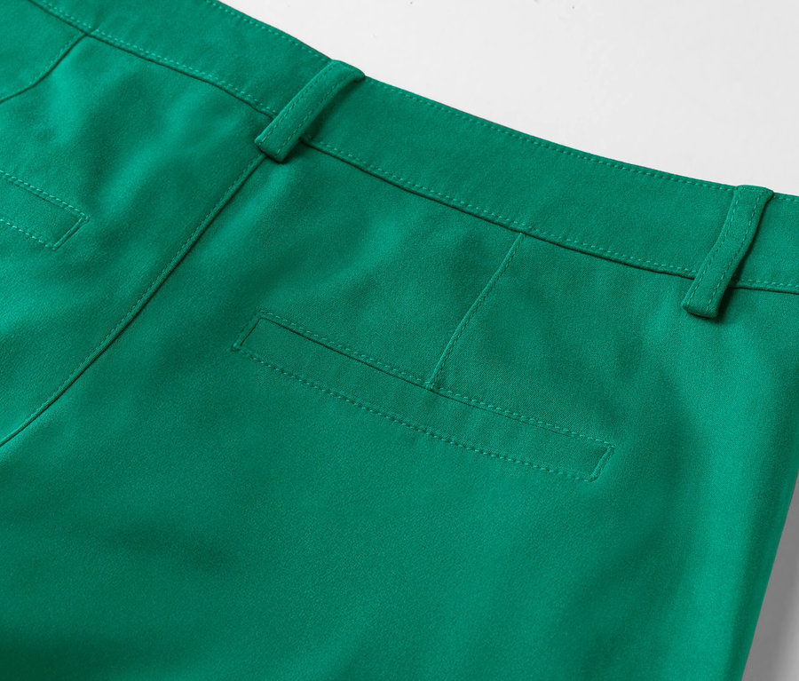 Detail zadní části smaragdově zelených kalhot s naznačenou kapsou.