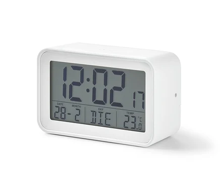 Bílý digitální LCD budík zobrazuje čas 12:02, datum 28-2 a teplotu 23 stupňů Celsia.