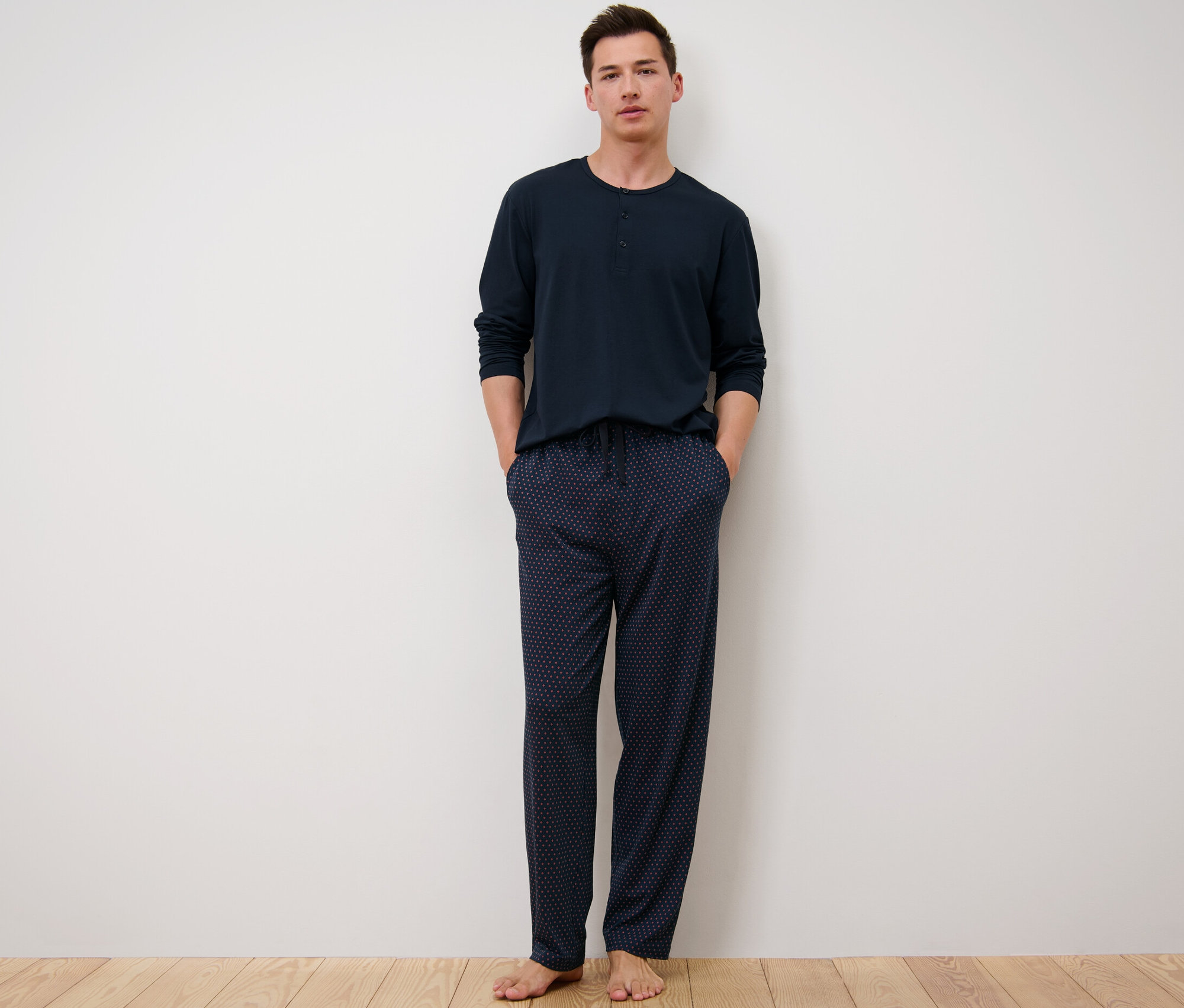 Muž stojí a má na sobě pyžamo s modalem.