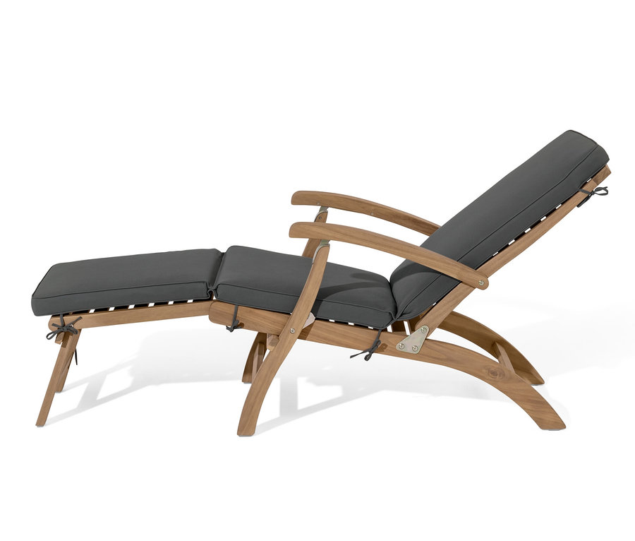 Lehátko s výsuvnou podnožkou s šedými polštáři.