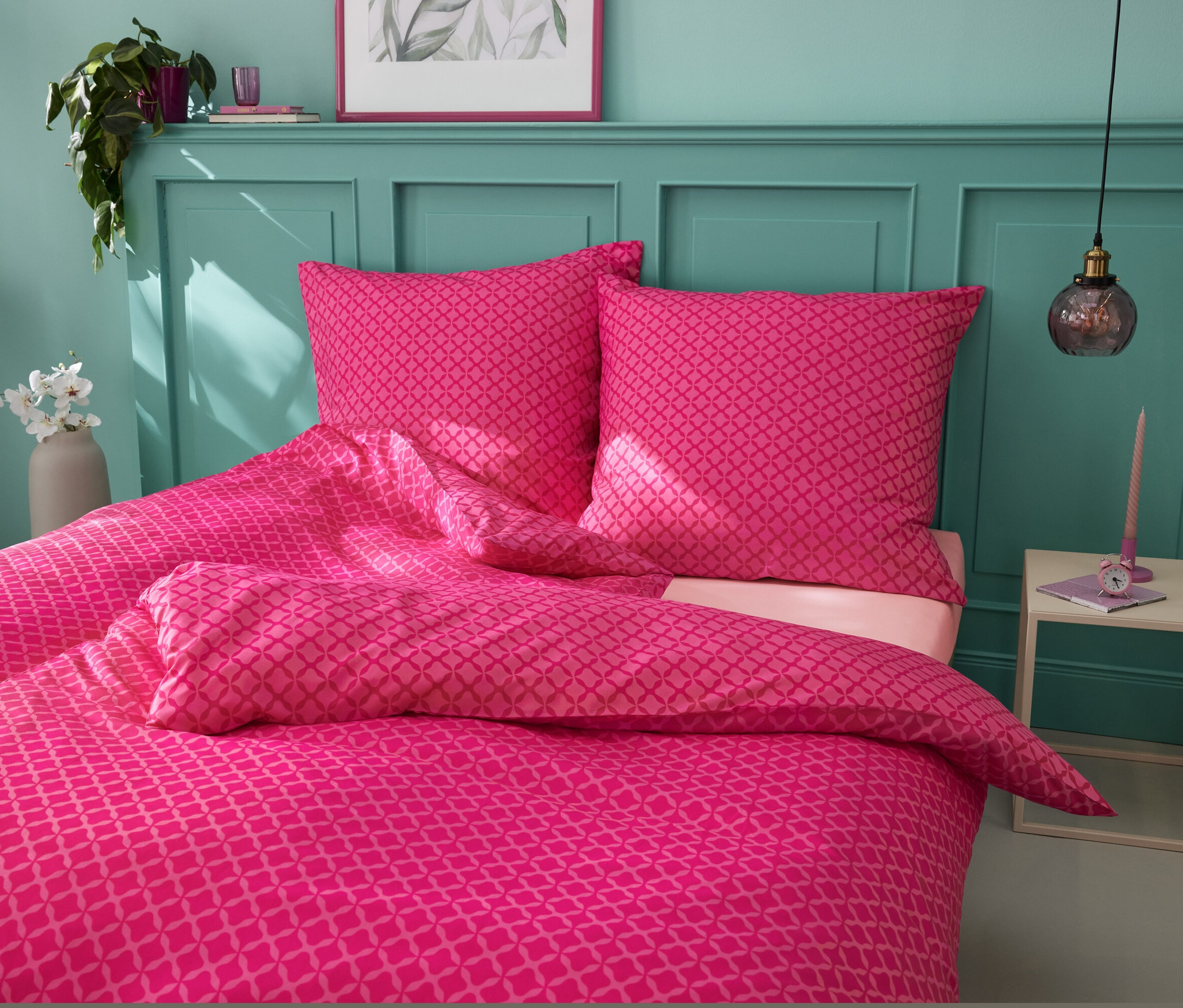 Růžové mikrovláknové povlečení standardní a nadměrné velikosti na posteli.