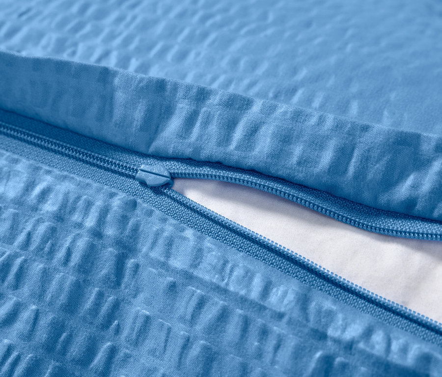 Detail modrého krepového povlečení se zipem.