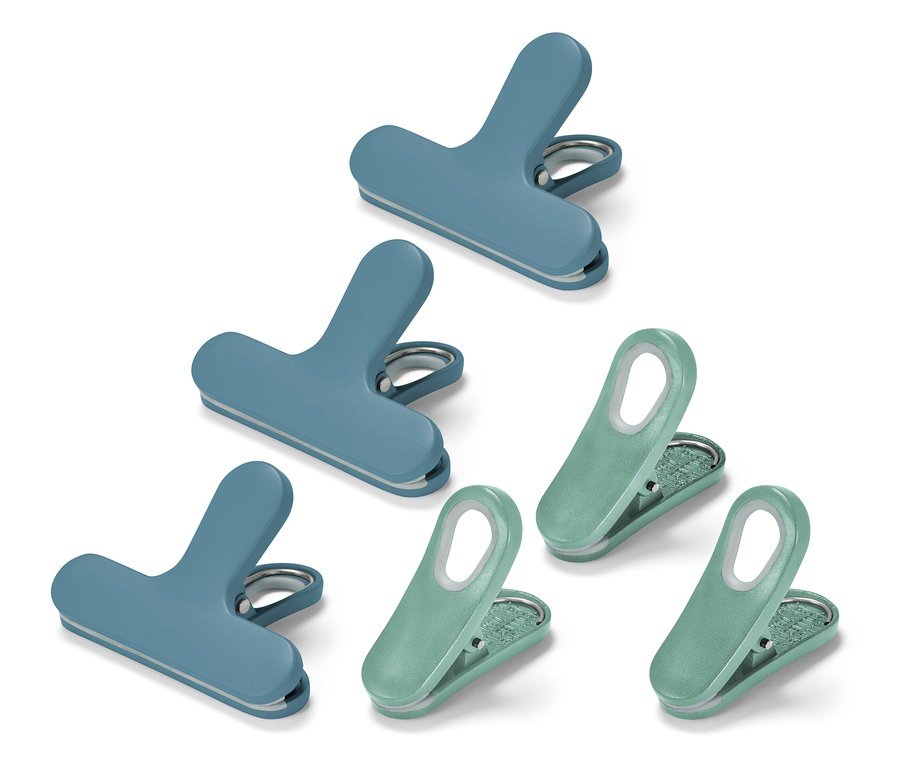 Pohled shora na tři modré a tři zelené klipsy na sáčky na bílém pozadí.