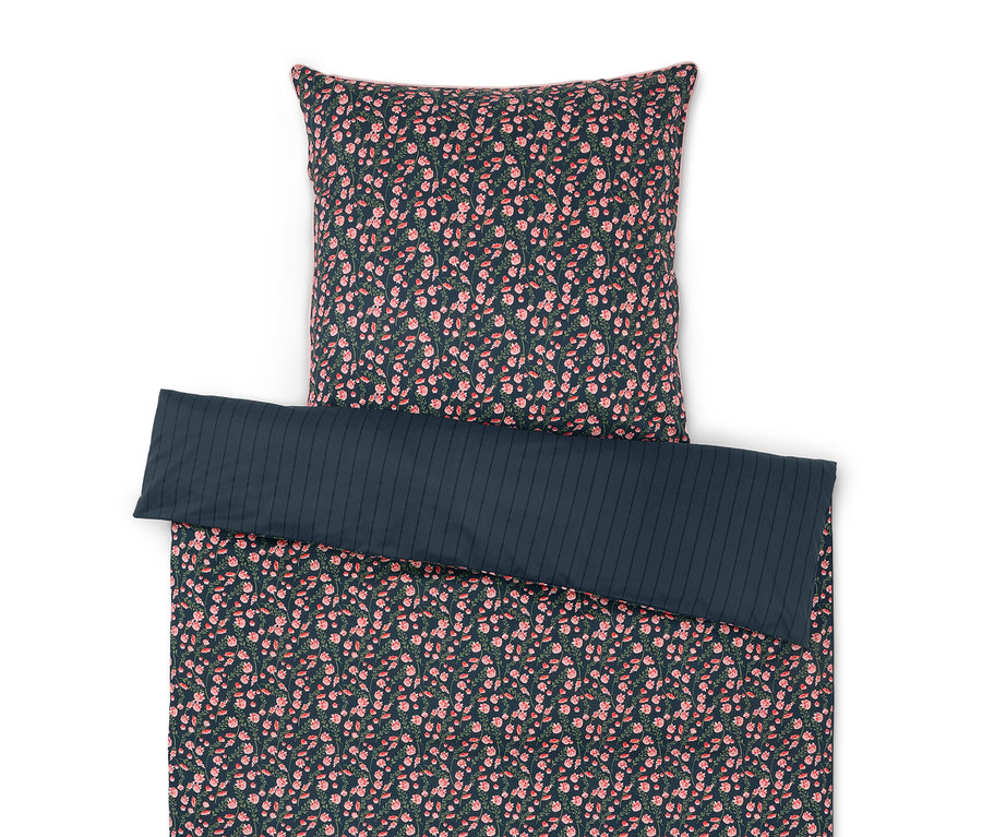 Povlečení s květinovým vzorem a jednobarevný polštář.