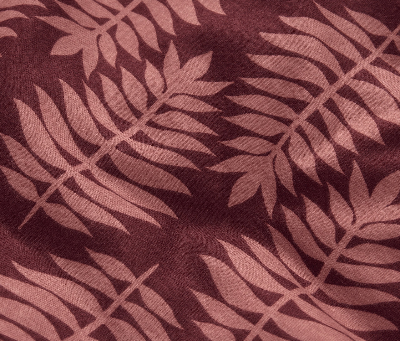 Detailní záběr na normální velikost zimního žerzejového ložního prádla s hnědým rostlinným vzorem.