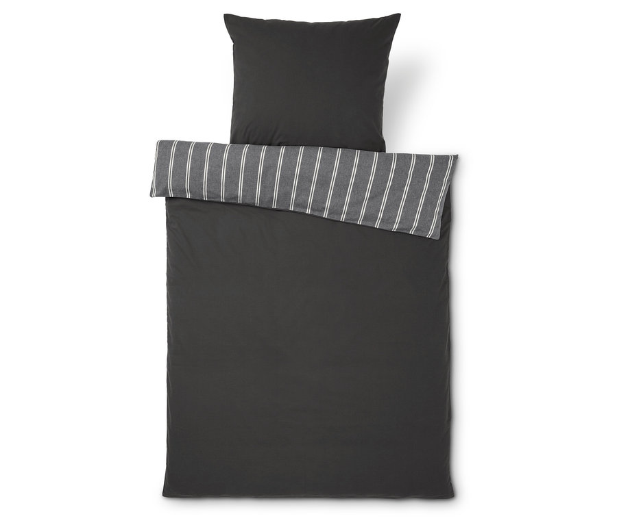 Tmavě šedé povlečení s pruhovaným lemem a polštářem.