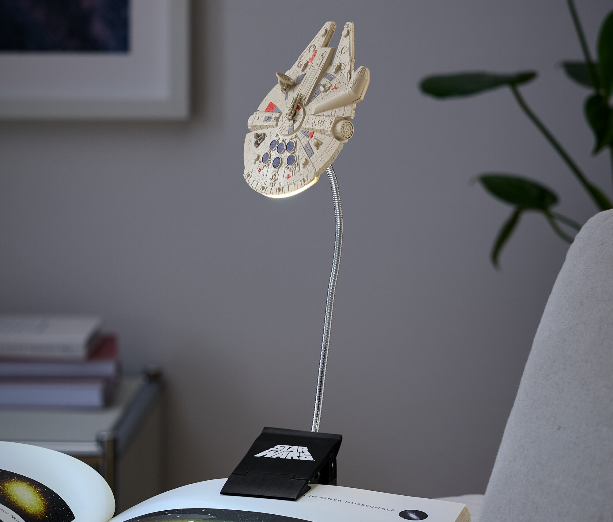 Lampa ve tvaru Millenium Falcon připevněná na knize.