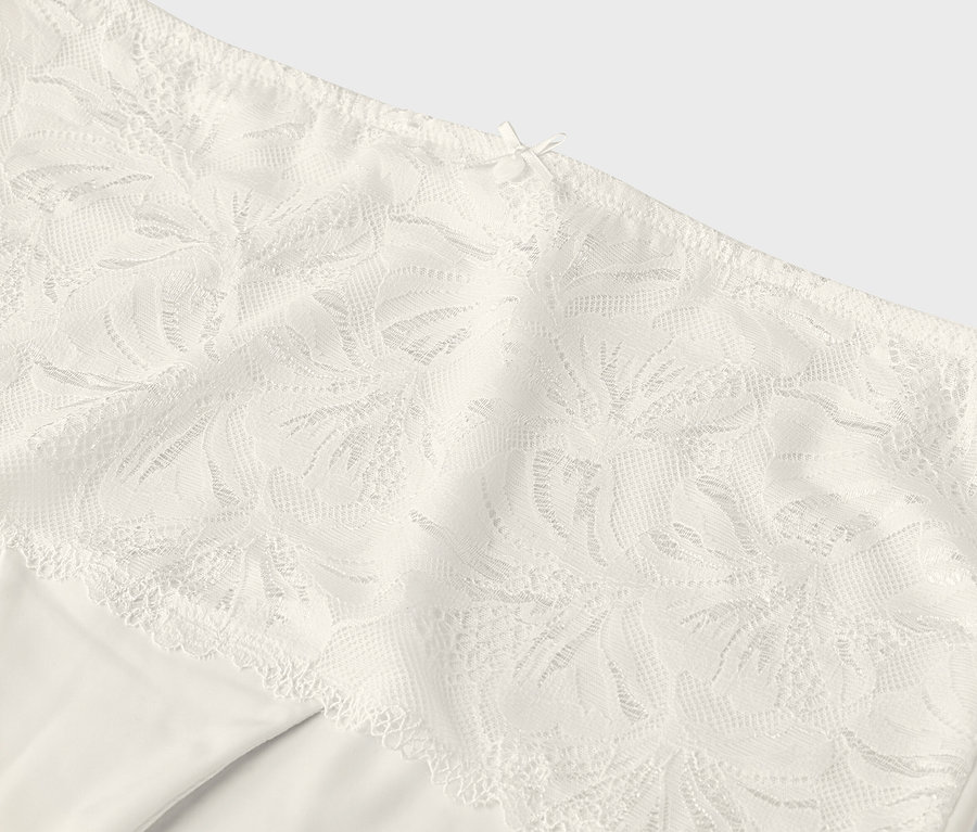 Detailní záběr na krémové kalhotky s krajkovým lemem.