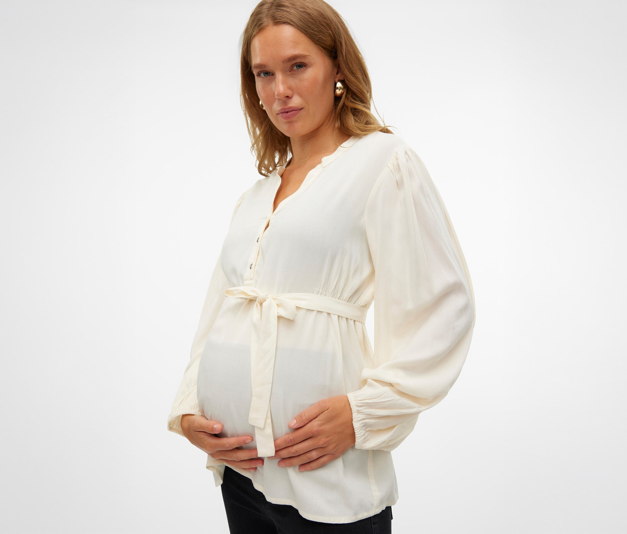 Těhotná žena drží si břicho a má na sobě halenku MAMALICIOUS MLMERCY LIA L/S WO TOP 2F NOOS.