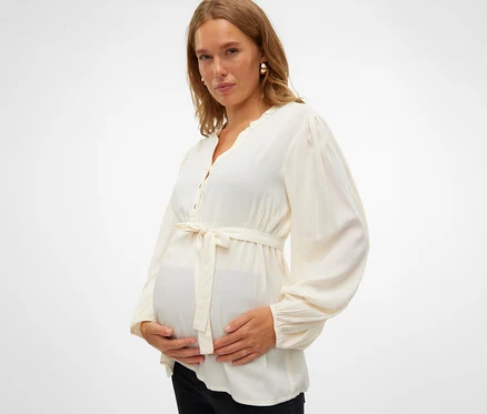 Těhotná žena drží si břicho a má na sobě halenku MAMALICIOUS MLMERCY LIA L/S WO TOP 2F NOOS.