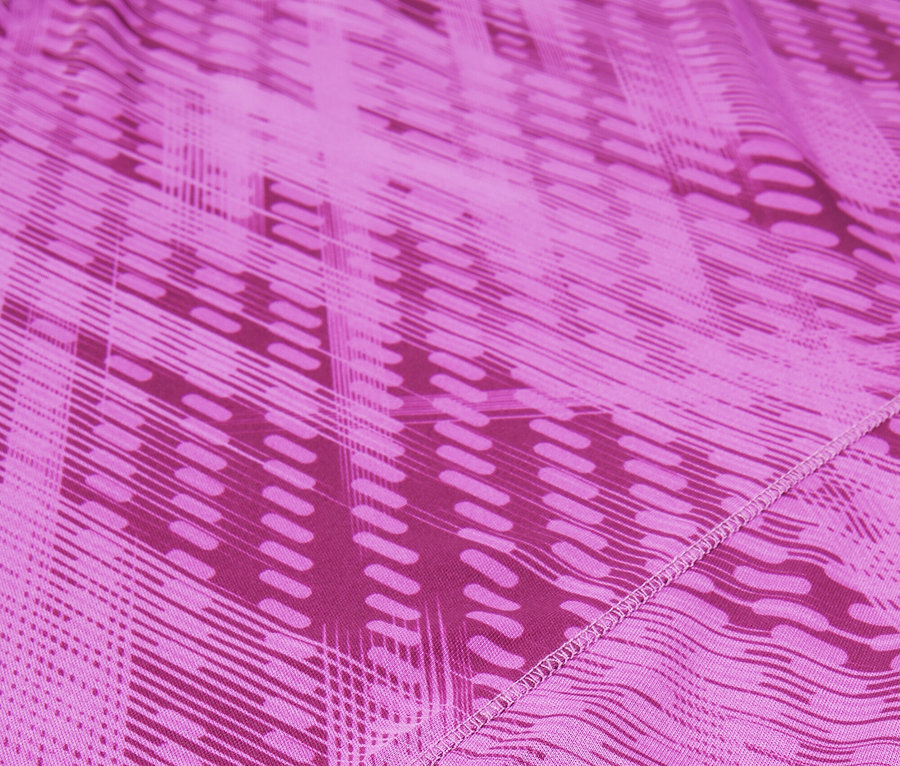 Detail růžové látky s geometrickým vzorem a logem FILA.