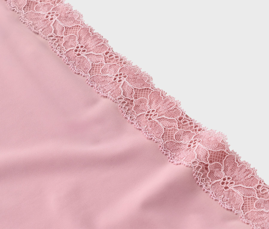Detailní záběr na růžovou látku s jemnou růžovou krajkou.