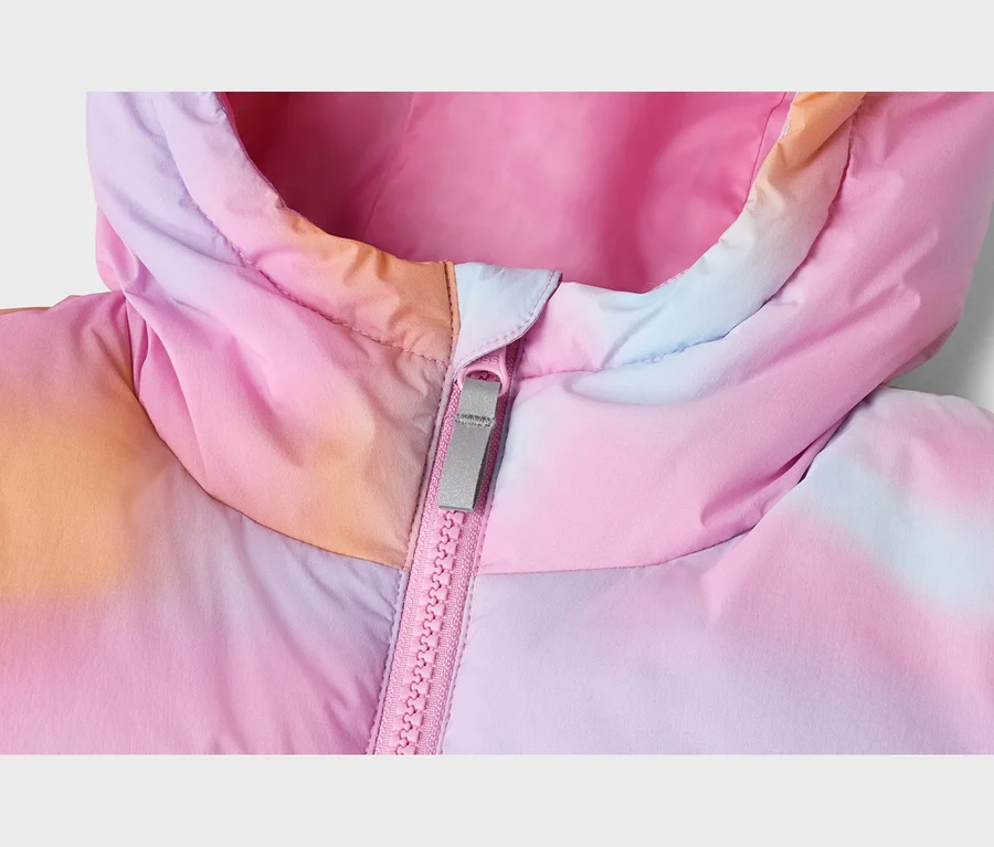 Detail prošívané bundy s kapucí v růžovém, oranžovém, fialovém a modrém tie-dye vzoru, s růžovým zipem a šedým jezdcem.