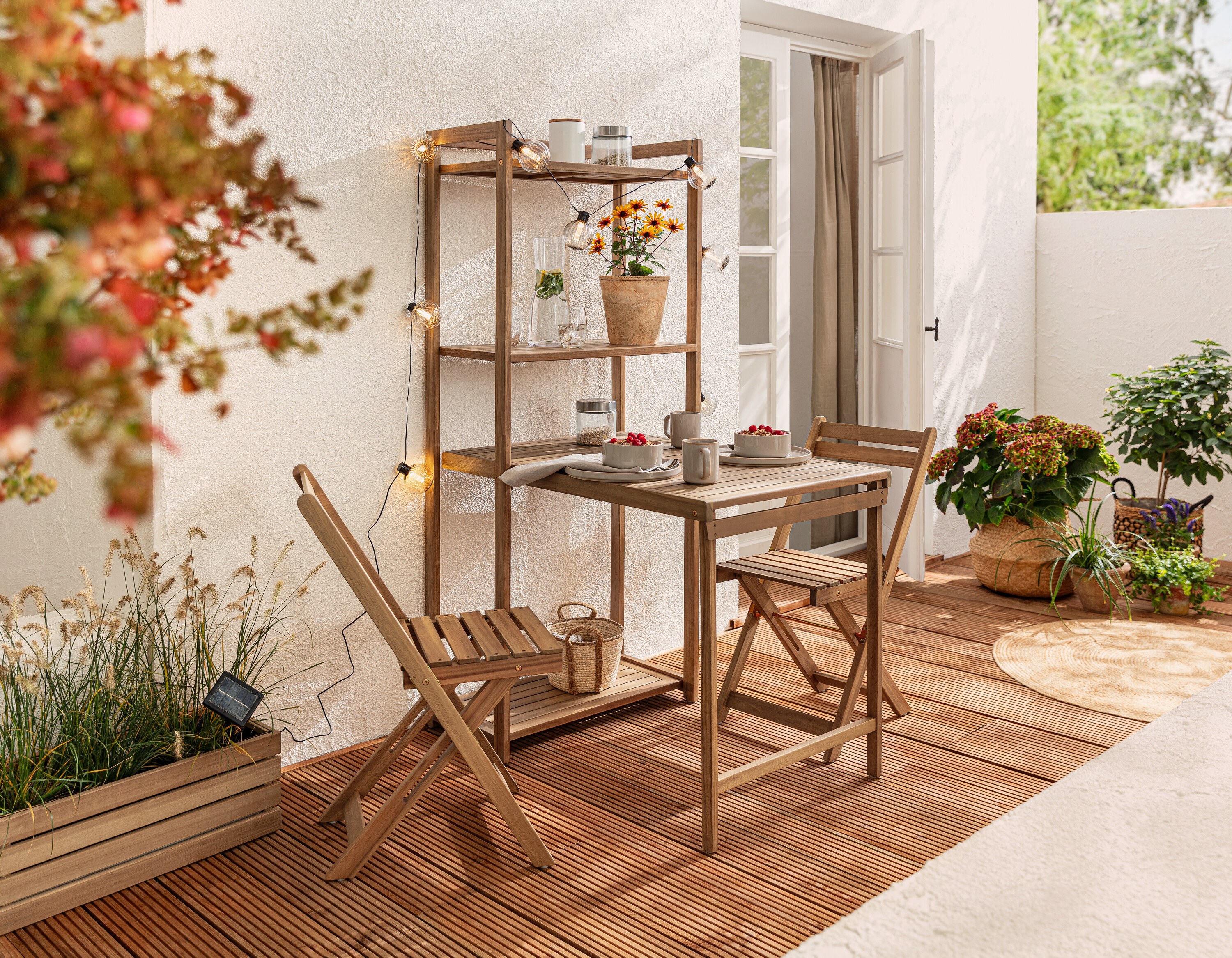 Balkónová jídelní souprava »Lenja« s regálem a solární světelný řetěz, kuličky s drážkami na balkóně.