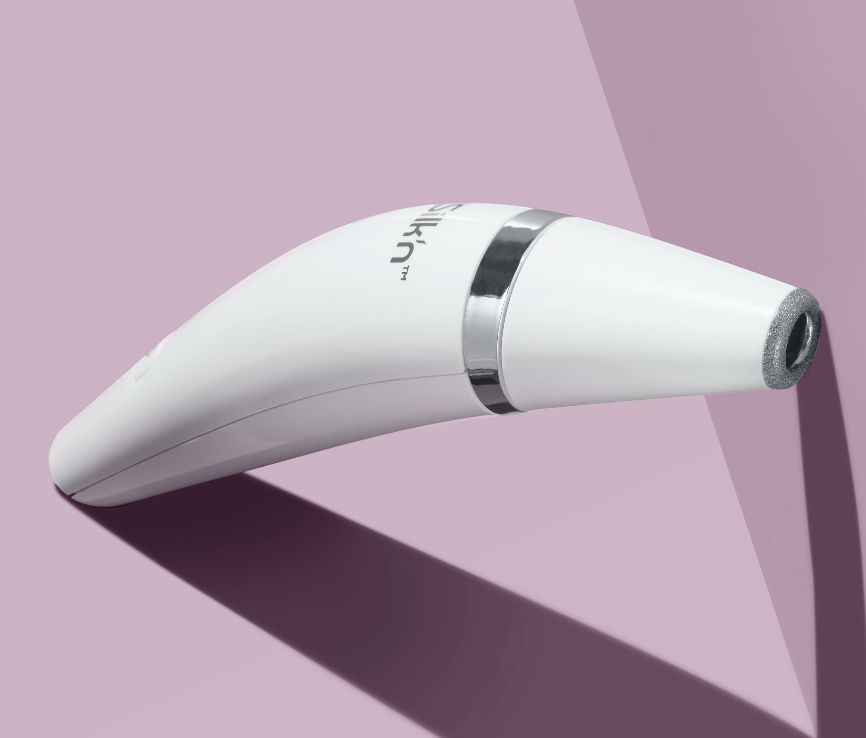 Detail bílého mikrodermabrazivního přístroje Silk’n® ReVit Essential na fialovém pozadí.