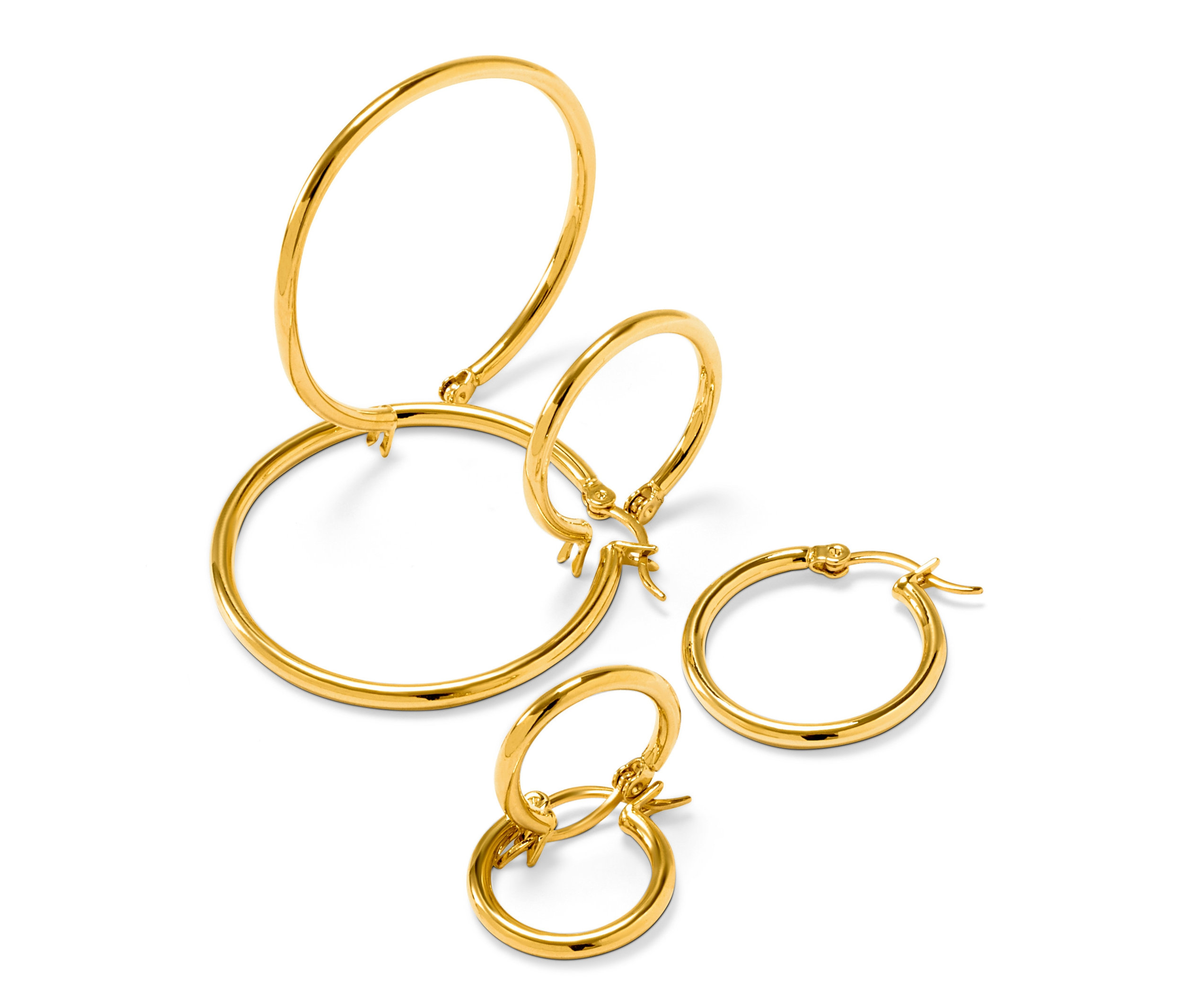 Čtyři páry zlatých kruhových náušnic na bílém pozadí.