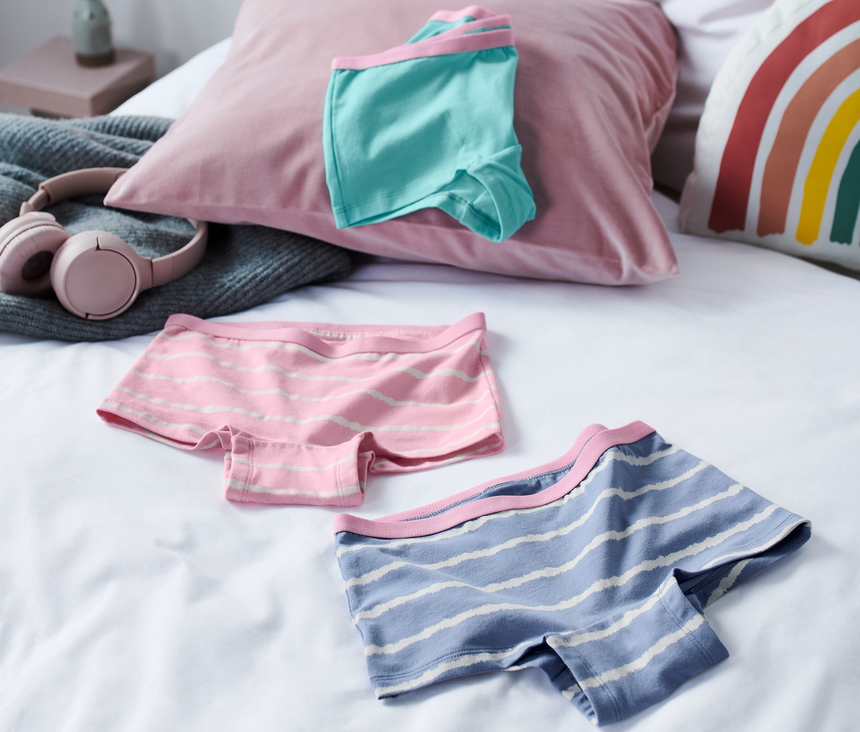 Na posteli leží troje dívčí kalhotky z biobavlny.