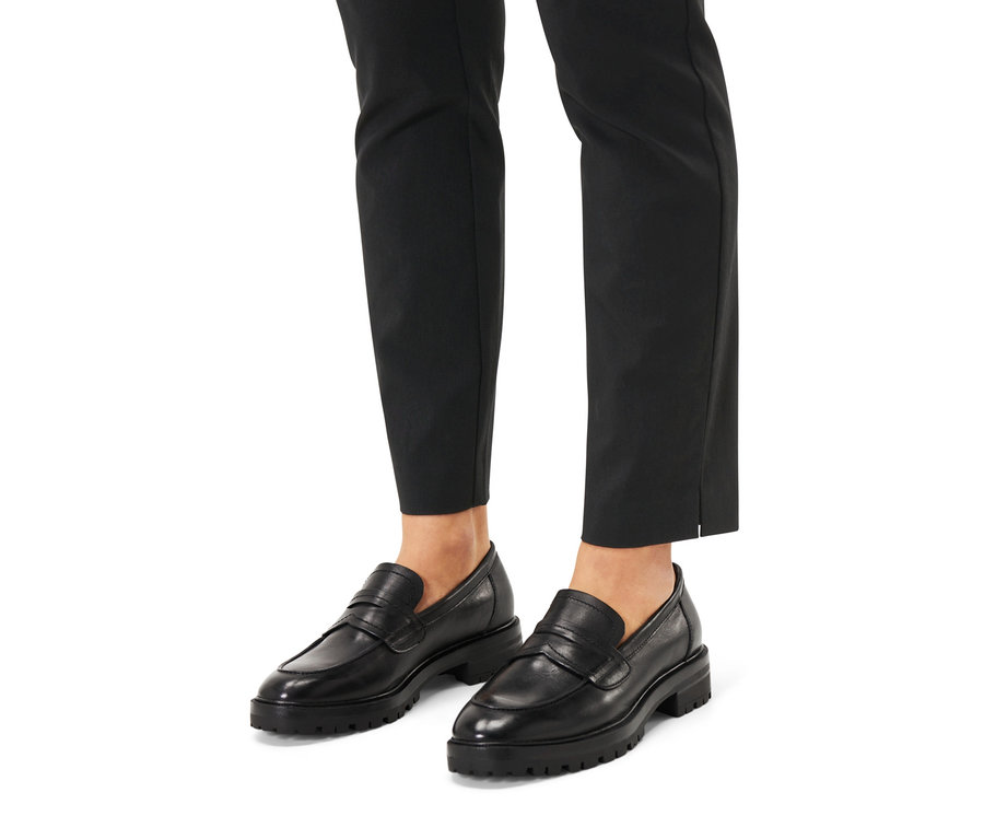 Nohy v černých kalhotách a kožených mokasínech.