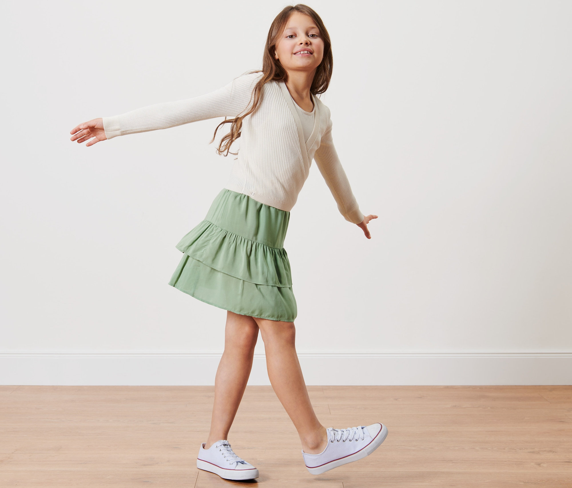 Dívka pózuje v dívčí stupňovité sukni.