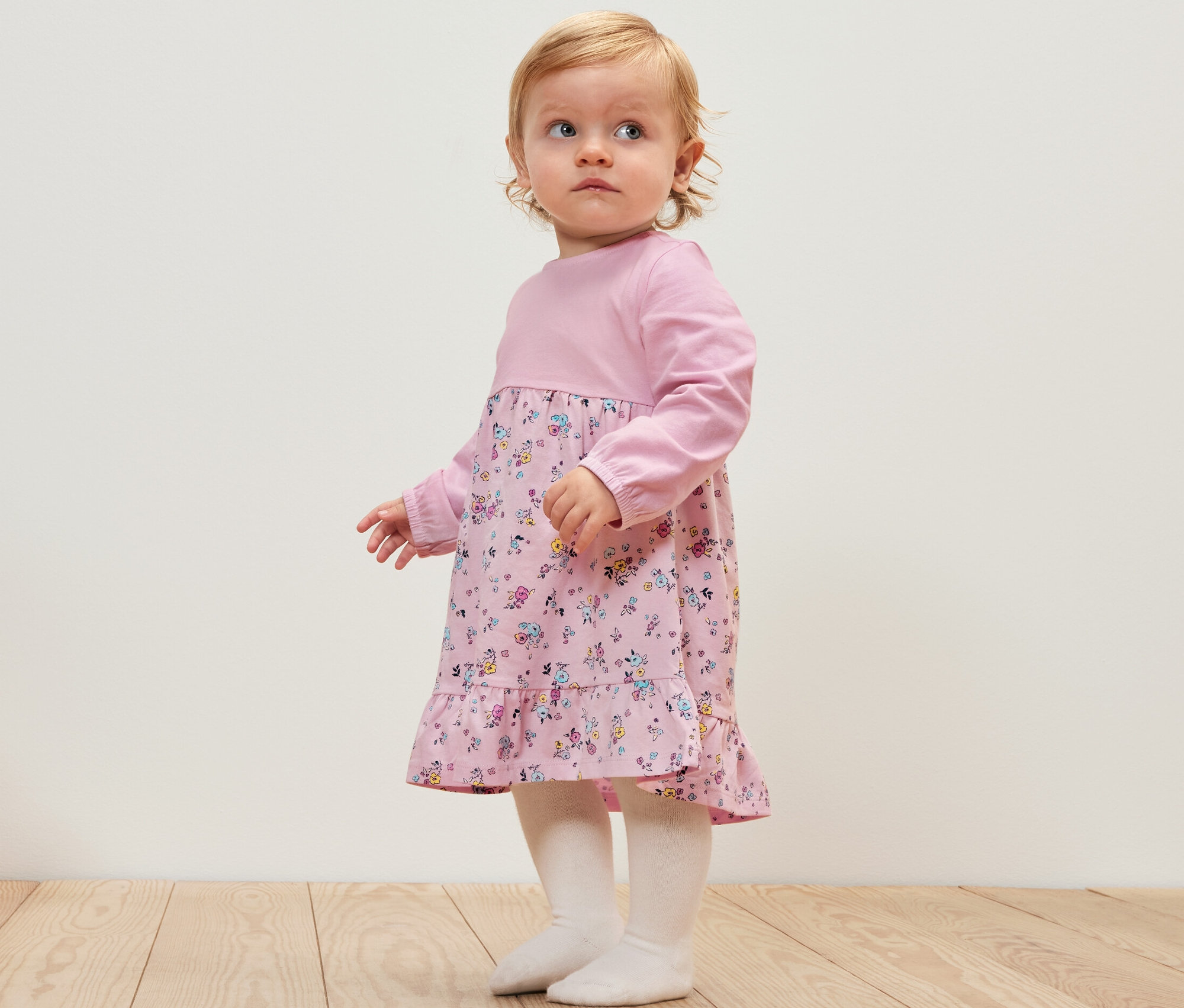 Batole v růžových žerzejových šatech.