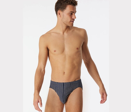 Muž pózuje v mini slipech SCHIESSER z biobavlny, tmavě modré barvy.