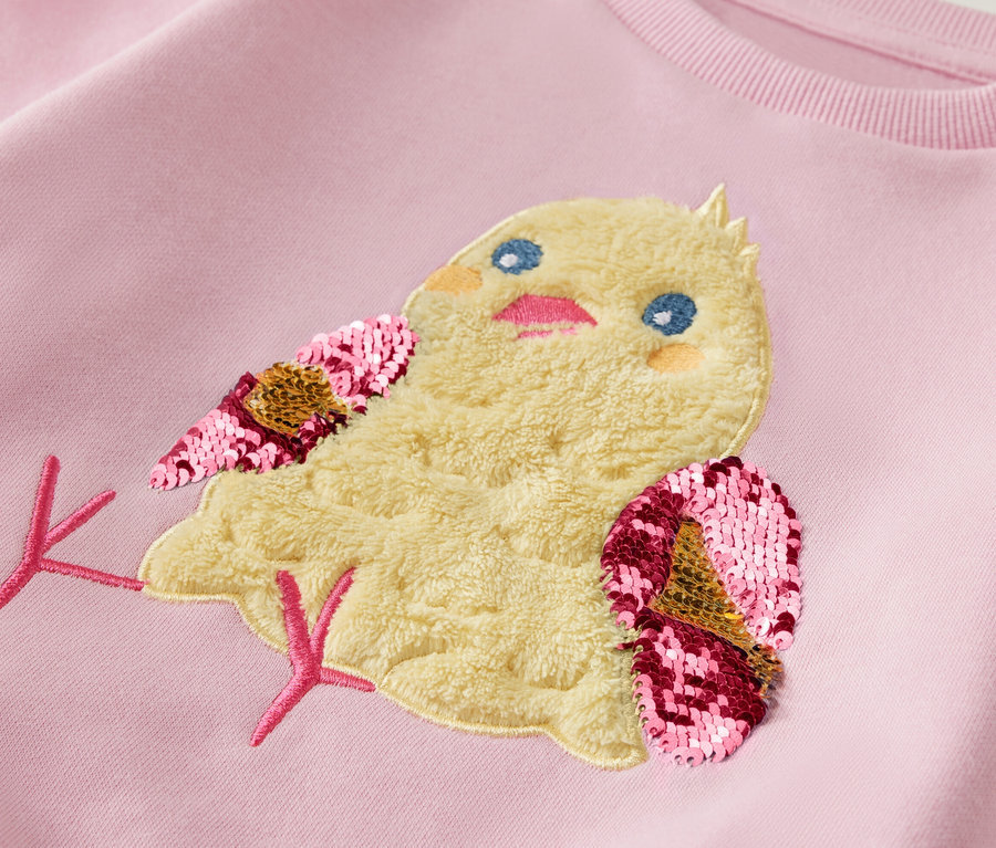 Světle růžová mikina s nášivkou kuřete s flitrovými křídly.