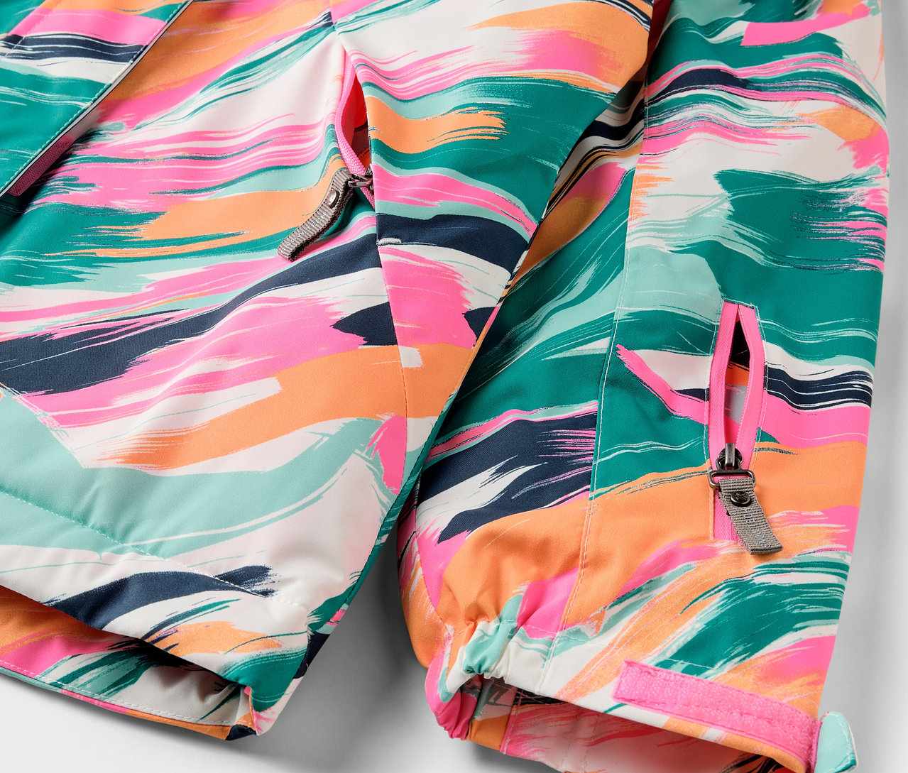 Detail pestrobarevné bundy se zipem.