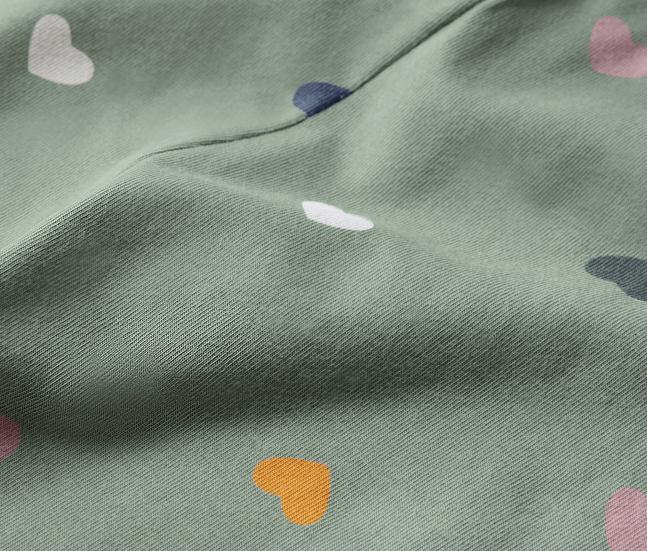 Detail dětských legín s potiskem lesních zvířátek a srdíček.