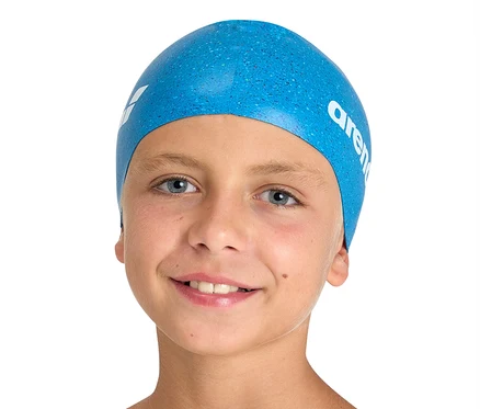 Usmívající se chlapec má na sobě modrou dětskou plaveckou čepici arena Junior Silicone.