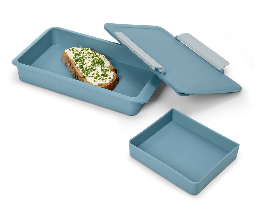 Chlebíček s bylinkami v modré svačinové krabičce s víkem a prázdná modrá krabička.