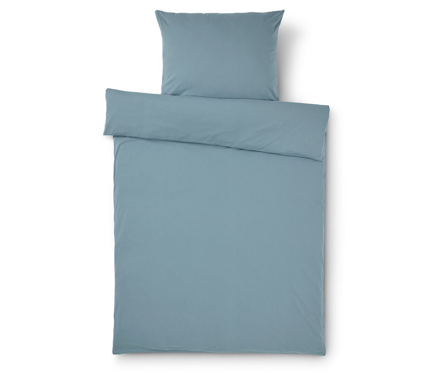Světle modré povlečení na přikrývku a polštář na bílém pozadí.