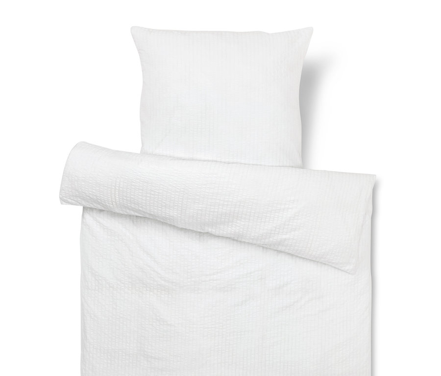Bílý povlak na polštář a přikrývku s texturou.